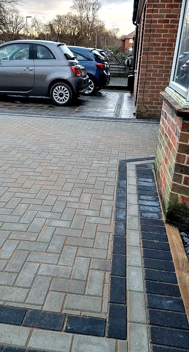 Block paved driveway with a contrasting border detail by the house