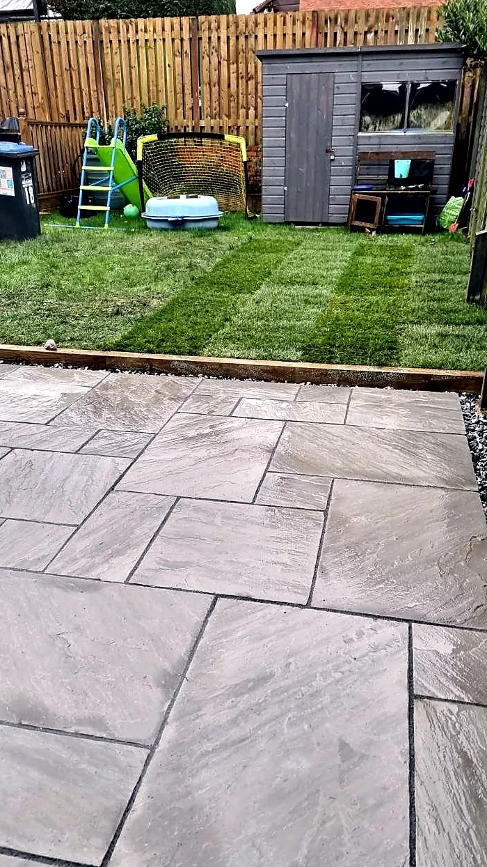 Bonwycks team installing garden paving beside an artificial grass lawn