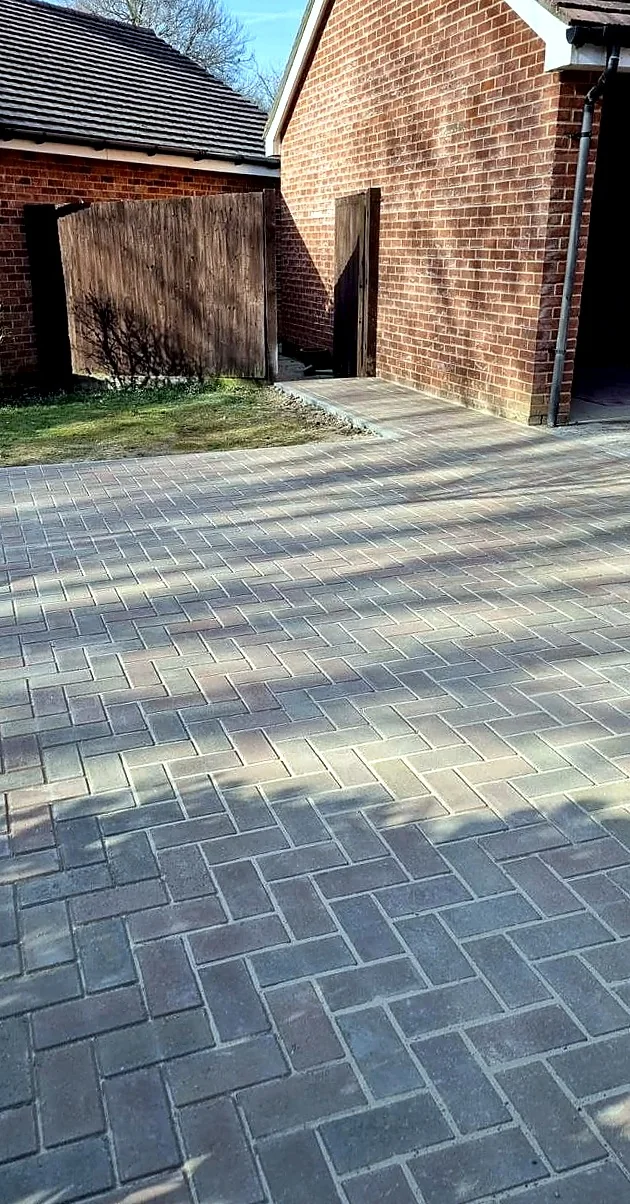 Grey block paved side driveway laid in a herringbone pattern